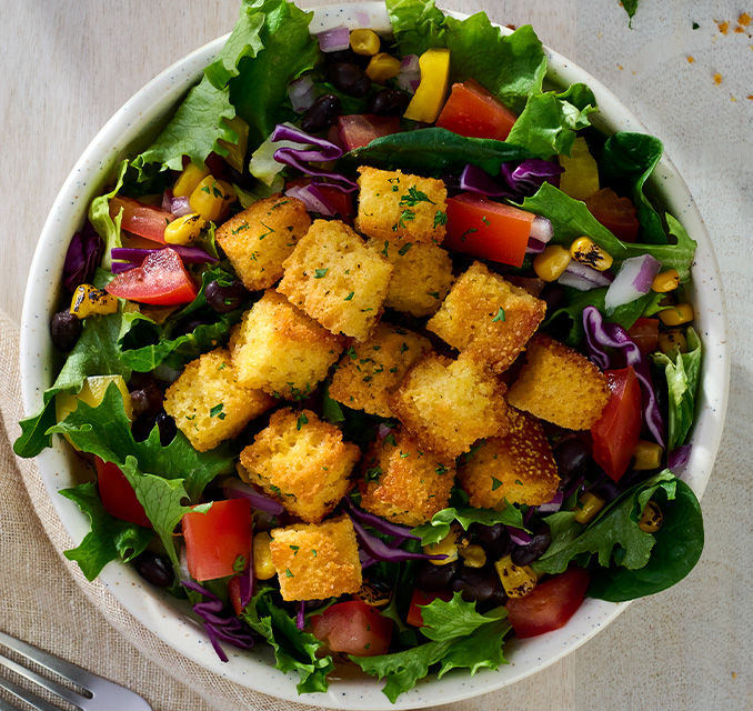 Cornbread Croutons on a leafy green salad